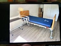 Full view of assembled hospital bed with mattress, rails and casters visible