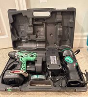 Open case showing drill, charger, flashlight, batteries, bit holder