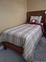 Entire twin bed assembled with bedding, showing headboard, footboard, mattress, boxspring and Nautica bedding