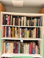 Three shelves filled with assorted hardcover and paperback books
