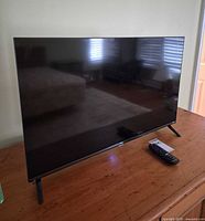 Front view of TV and remote on table