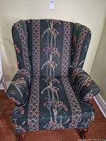 Front view of upholstered wingback chair showing full design and legs