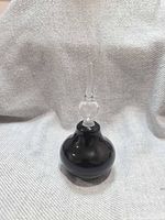 Full view of perfume bottle showing black amethyst body and clear stopper