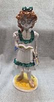 Front view of signed Bencini schoolgirl figurine with book