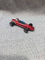 Left side view of red Spectraflame Indy Eagle showing wheels, windshield, spoiler