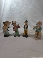 Front view of four musician figurines standing and seated