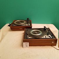 Pair of wooden-cased Dual brand turntables placed on cloth surface, visible model numbers 1216 and 1218, showing general condition and layout.