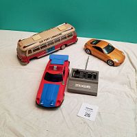 Photo showing all three items - tin bus, remote control car with controller, and diecast car