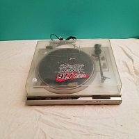 Front view of Spectrum DDS-33 turntable with dust cover closed showing logo on dust cover and front controls.