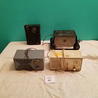 All four radios arranged on a beige cloth showing size and color differences
