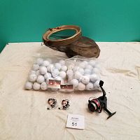 Photo showing two clear bags filled with used golf balls, a fishing reel with black and red accents, two new Belleville Bulls mascot keychains in packaging, and a collapsible mesh bait bucket with a wire frame.