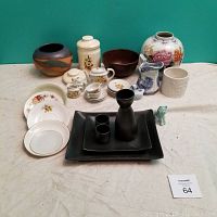 Wide view of all ceramic items in the lot including saki set, bowls, vases, plates, and figurine.