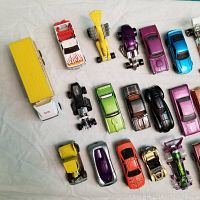Overview of first row of Hot Wheels cars showing yellow semi-truck, white flame truck, dragsters, classic and muscle cars in various colors