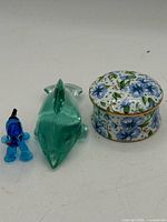 Group shot showing blue glass dog, green glass dolphin, floral trinket box
