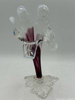 Front view of blown glass flower vase showing flared petal rim and purple stem
