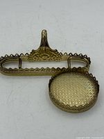 Stand separated into saucer base and back support, showing etched pattern and pierced edging