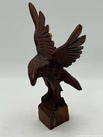 Front left view of carved eagle sculpture on base