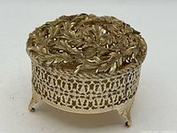 Closed view showing ornate leaf lid and filigree sides