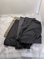 Four pairs of wool slacks folded on hanger