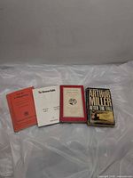 Four play books laid out showing front covers