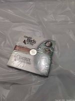 Front of sealed Birds of Prey coin booklet showing coin aperture and graphics