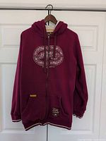 Front view of burgundy Ecko Unltd. zip hoodie on hanger showing chest graphic and overall condition