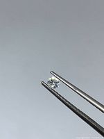 Diamond held in tweezers front view