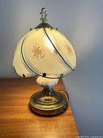 Full view of lamp illuminated, showing shade, base and cord