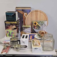 Front view showing toaster, flour sifter, measuring cups, boxed corn popper, boards, plates, tray, glass jar