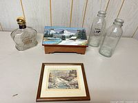 Group shot of decanter, painted box, two milk bottles and framed print