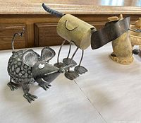 Metal mouse and dog sculptures on tabletop