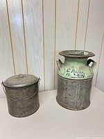 Front view of galvanized lidded pail and milk can