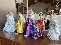 All six dolls standing on surface displaying outfits and accessories
