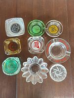 Top-view of all nine ashtrays showing shapes, colors and logos