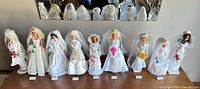 Group shot of all nine bridal Barbie dolls with era labels