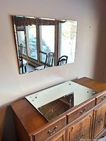 Both mirrors shown, one mounted and one resting on dresser