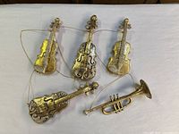 Group of five ornaments: four violins, one trumpet