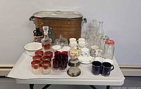 Full lot showing metal tub, glassware, teacups, tumblers, coasters, bottles, enamel bowl