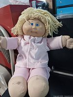 Full view of doll seated in pink sleepwear