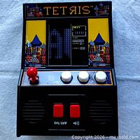 Front view of black Tetris mini arcade handheld