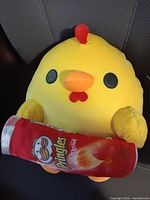 Front view of plush duck holding Pringles can