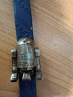 Close-up of silver-tone R2-D2 watch head on blue strap