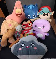 Group shot of all eight plush toys on chair