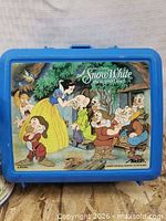 Front view of blue Snow White lunch box showing graphic