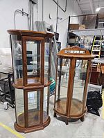 Both wood and glass curio cabinets side by side showing overall design and size comparison