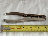 Full view of nutcracker beside tape measure showing length