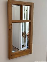 front view of mirror showing three-pane layout in wooden frame