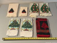 All eight towels laid out with measuring tape for scale