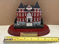 Front view showing full building, plaque and tape measure for scale