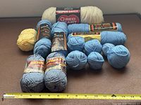 Group shot of all yarn pieces with measuring tape for scale